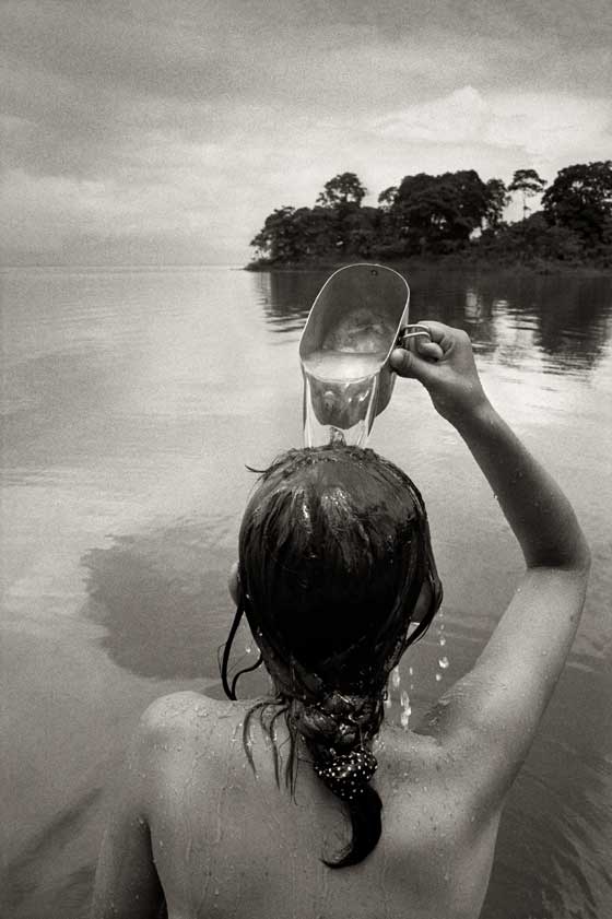Fotografía en blanco y negro de una niña bañándose en un lago 