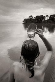 Fotografa en blanco y negro de una nia bandose en un lago.